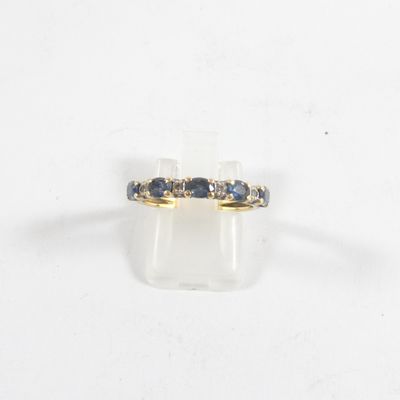 gros plan d'une bague en or avec des saphirs bleus