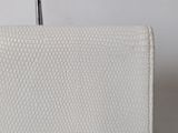 a close up of a white purse on a table