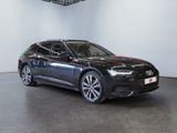 a black audi is parked in a large room with white walls
