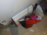 un sac posé par terre à côté d'un radiateur