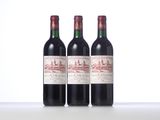 three bottles of red wine sitting on top of a white table