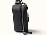 a black purse with a chain hanging from it ' s side