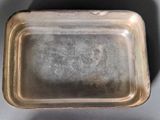 a silver tray with a handle on a table