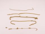 a collection of gold necklaces and bracelets on a white background