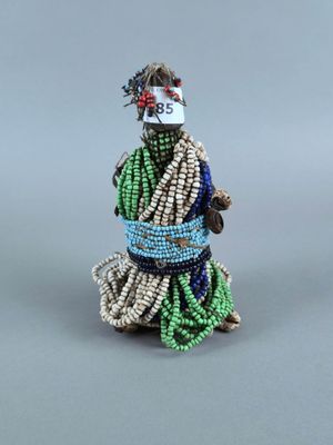 figurine en perles représentant une femme vêtue d'une robe verte et d'un chapeau