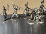 five figurines of soldiers on a metal surface