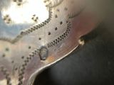 a close up of a silver spoon with writing on it