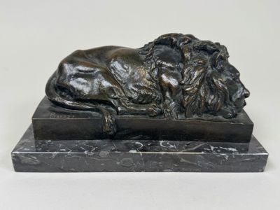 statue en bronze représentant un lion posé sur un socle en marbre