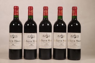 quatre bouteilles de vin rouge sont alignées sur une table