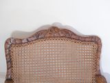 a wicker chair that is sitting in the corner of a room