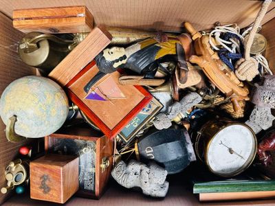 une boîte en carton remplie d'objets divers, notamment une horloge et d'autres objets