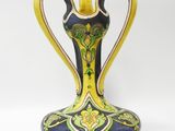 a blue and yellow vase sitting on a white surface