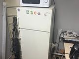 a microwave on top of a refrigerator in a kitchen