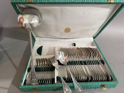 un coffret vert contenant de l'argenterie sur une table