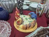 a cake on a plate on a table with plates and vases
