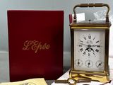 a small clock sitting on a table next to a box