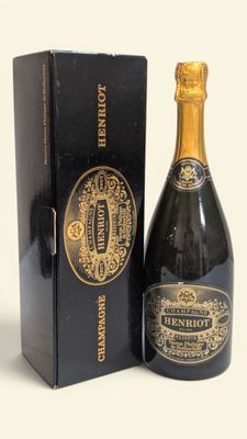 une bouteille de champagne dans un coffret noir, à côté d'un autre coffret noir