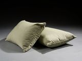 two pillows on a gray surface with a black background