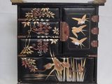 une armoire noire ornée d'un motif représentant un oiseau