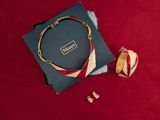 a close up of a box with a necklace on it next to a pair of scissors