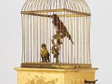 un oiseau dans une cage, avec un autre oiseau à l'intérieur