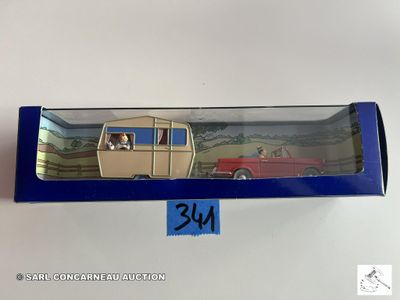 une image représentant une boîte contenant une petite voiture et une boîte sur laquelle figure la photo d'un homme dans une voiture