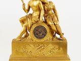une image représentant une statue en or d'un homme et d'une femme tenant une horloge