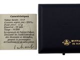 un petit portefeuille noir avec une pièce à côté