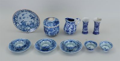 Plusieurs pièces de porcelaine bleue et blanche sont disposées sur une table
