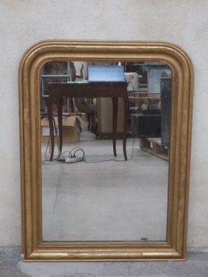 a mirror on the wall reflecting a table and a chair