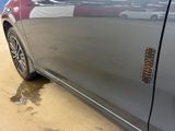 a close up of a car ' s door handle with a puddle of water on the ground