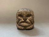 an image of a small statue of a face on a table