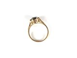 a close up of a gold ring with a black stone