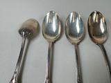three silver spoons and a spoon with a spoon rest on a table