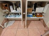 deux étagères dans un coin de la salle de bains, avec une serpillière posée par terre