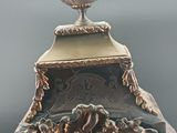 a clock that has a bird on top of it