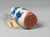 a small blue and white vase with a tag on it