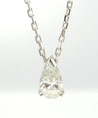 un gros plan d'un pendentif en diamant blanc monté sur une chaîne