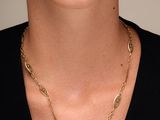 une femme portant un t-shirt noir et un collier à chaîne dorée