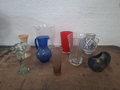 de nombreux vases de différentes couleurs posés sur une table en bois