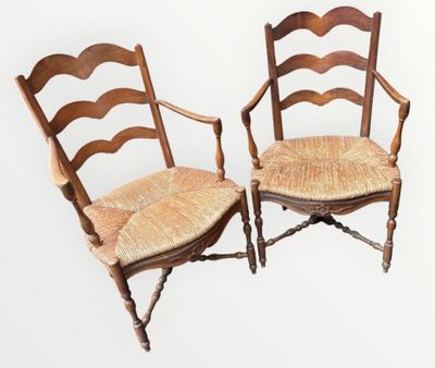 une paire de chaises anciennes à dossier en échelle, avec des coussins en rotin sur fond blanc