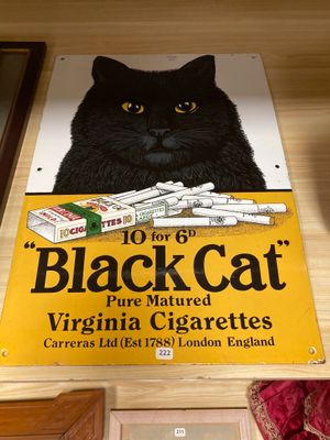 un chat noir assis sur une boîte de cigarettes
