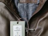 brown leather jacket with a label on the back of it