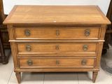 une commode en bois avec des poignées et des boutons en laiton