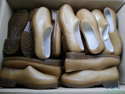 many pairs of shoes in a box on the floor