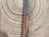 a knife that is sitting on a piece of wood
