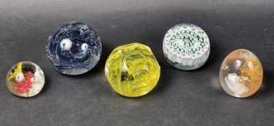 six different colored glass marbles sitting on top of a black surface