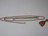 a close up of a necklace with a triangle shaped pendant on a chain