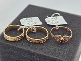 three gold rings and a tag on a black box
