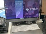 un écran d'ordinateur posé sur un bureau devant une fenêtre